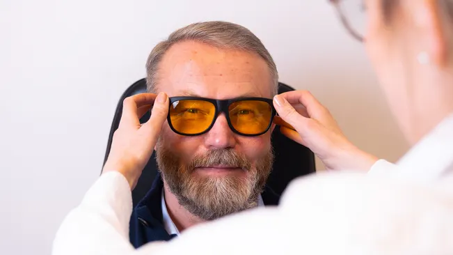 Mann med filterbriller fra hjelpemiddelsentralen